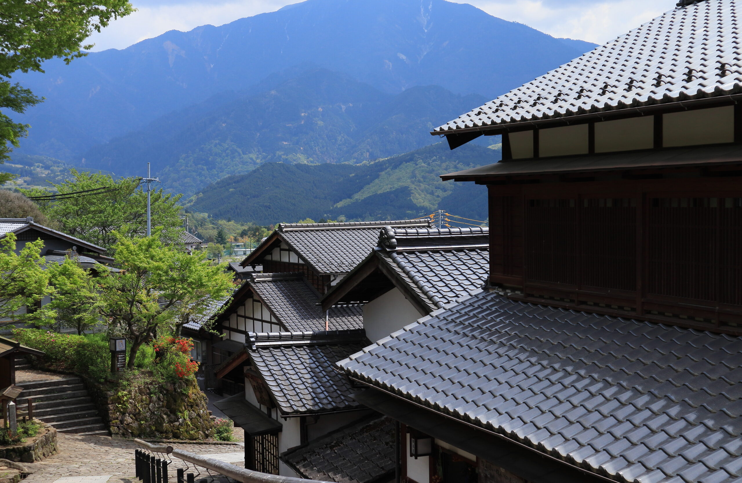 山間に建つ瓦屋根の日本家屋